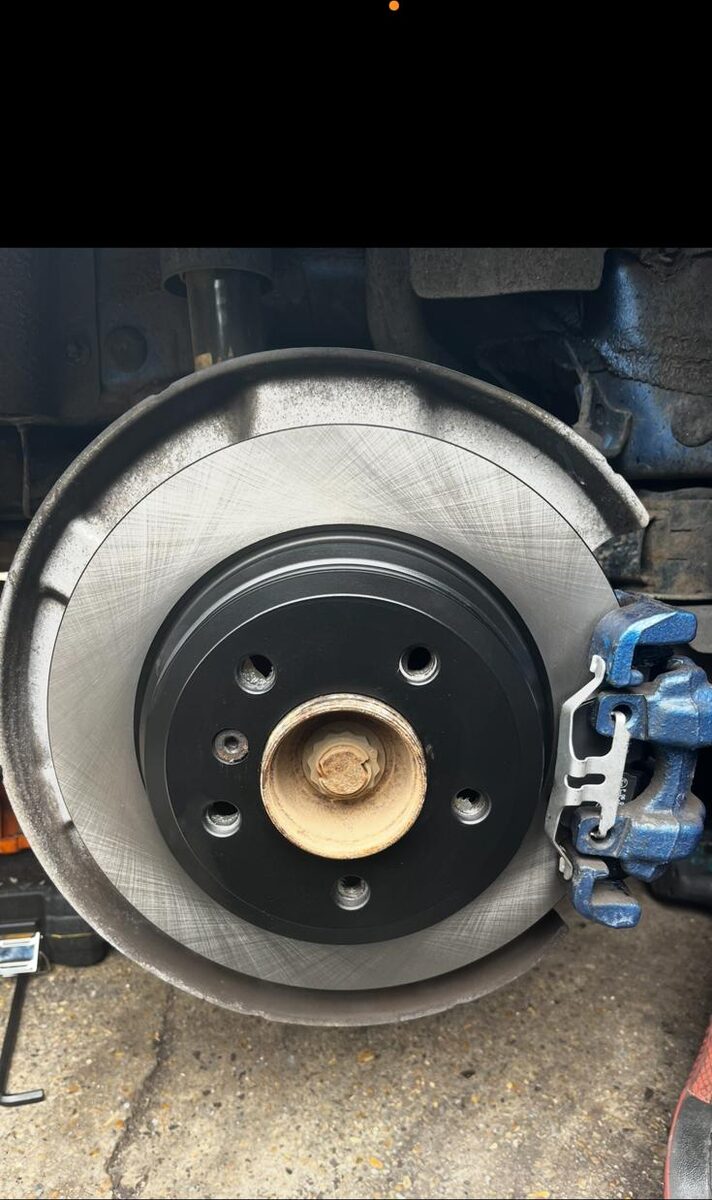Freshly fitted brake disc and caliper on a vehicle