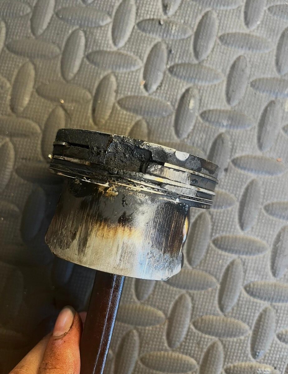 Piston removed from an engine showing heavy carbon build-up