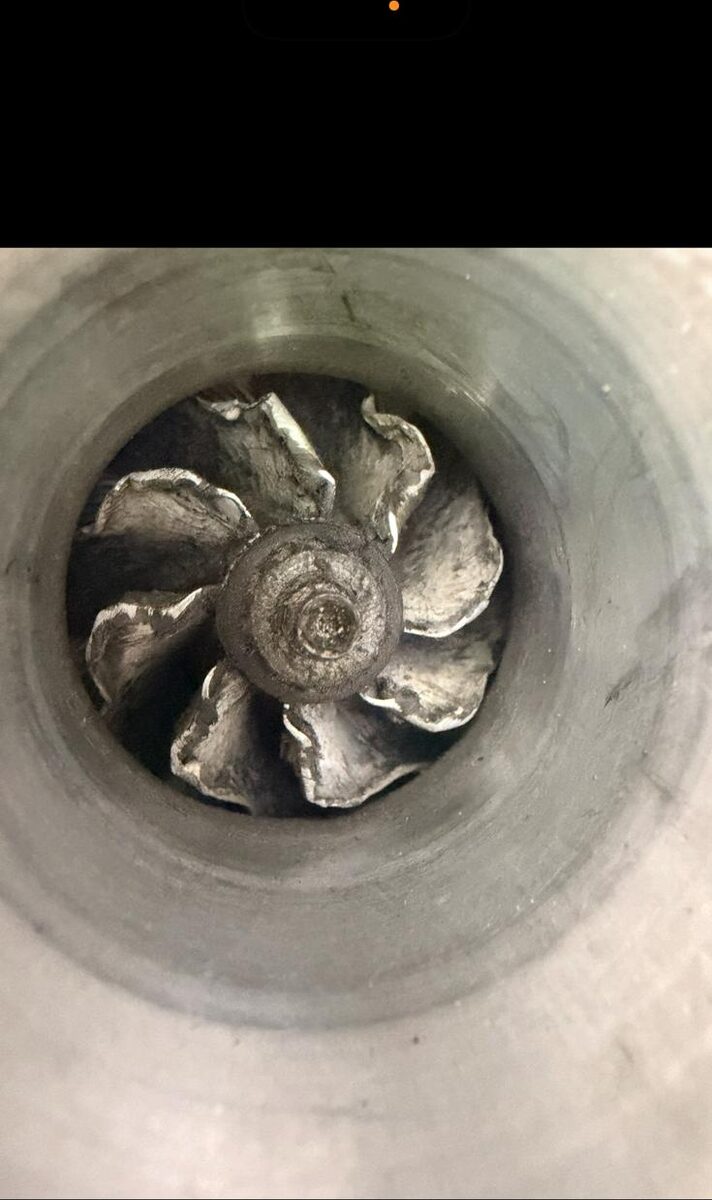 Damaged turbocharger compressor wheel seen through the housing